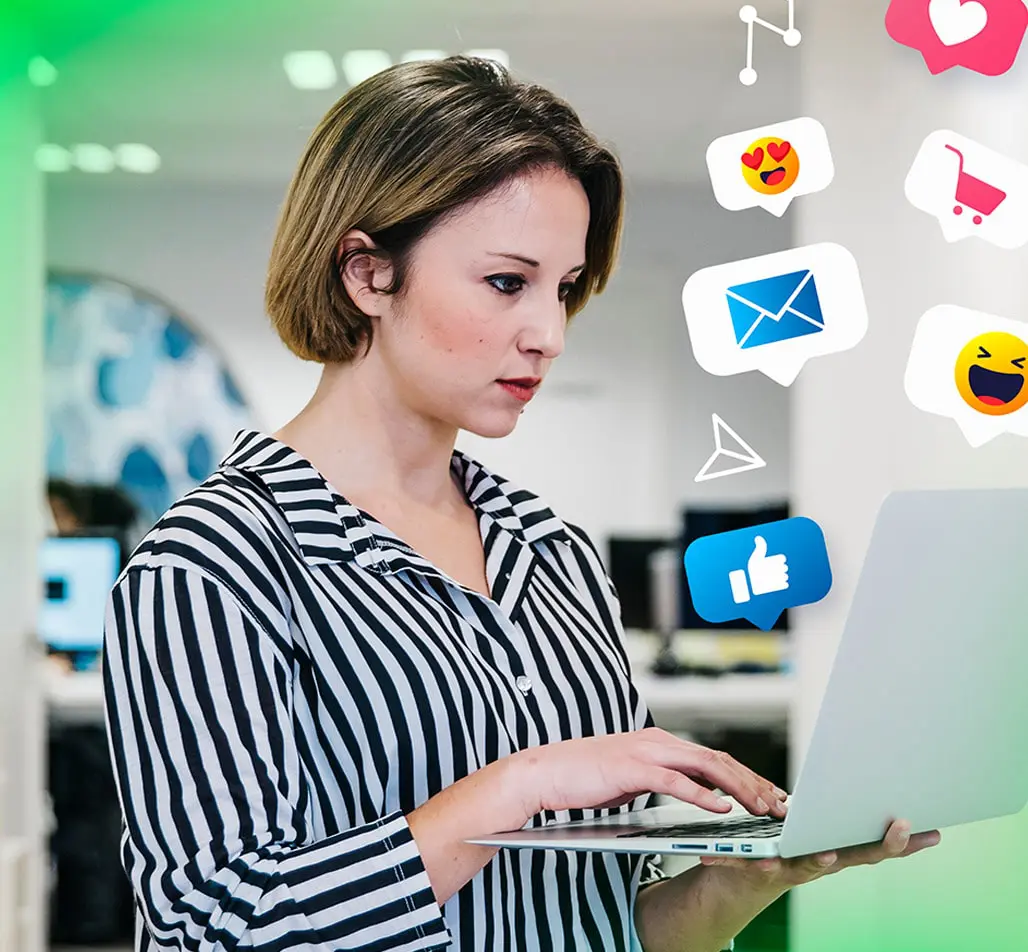 Mulher usando laptop em um ambiente de escritório, cercada por ícones de redes sociais representando curtidas, mensagens e carrinho de compras, simbolizando o trabalho de engajamento digital da Agência War para aumentar a interação e presença online.