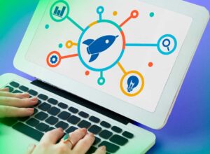 Laptop exibindo um gráfico com ícone de foguete no centro, conectado a ícones de análise, pesquisa, ideias e engrenagem, simbolizando o crescimento e inovação em estratégias de marketing digital.